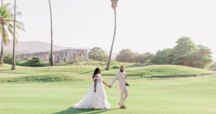 Bride and groom walking across a tropical golf course at a luxury resort during their destination wedding in Punta Cana.
