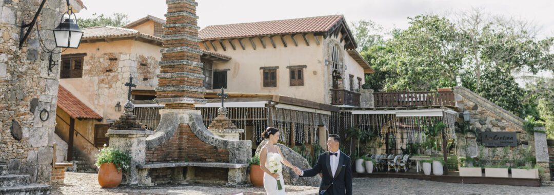 Newlywed couple walking through a historic stone venue during their destination wedding in the Dominican Republic.