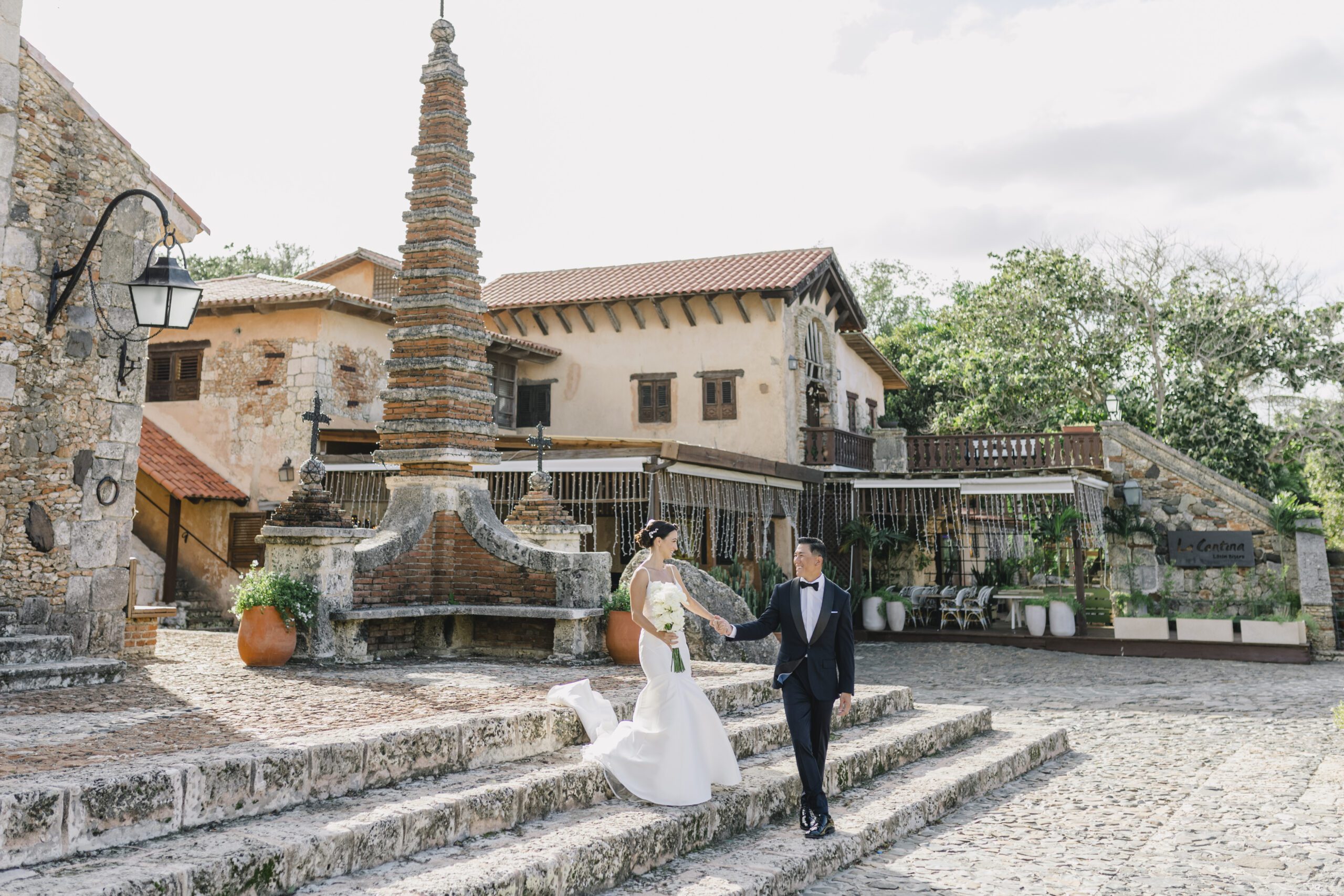 Newlywed couple walking through a historic stone venue during their destination wedding in the Dominican Republic.